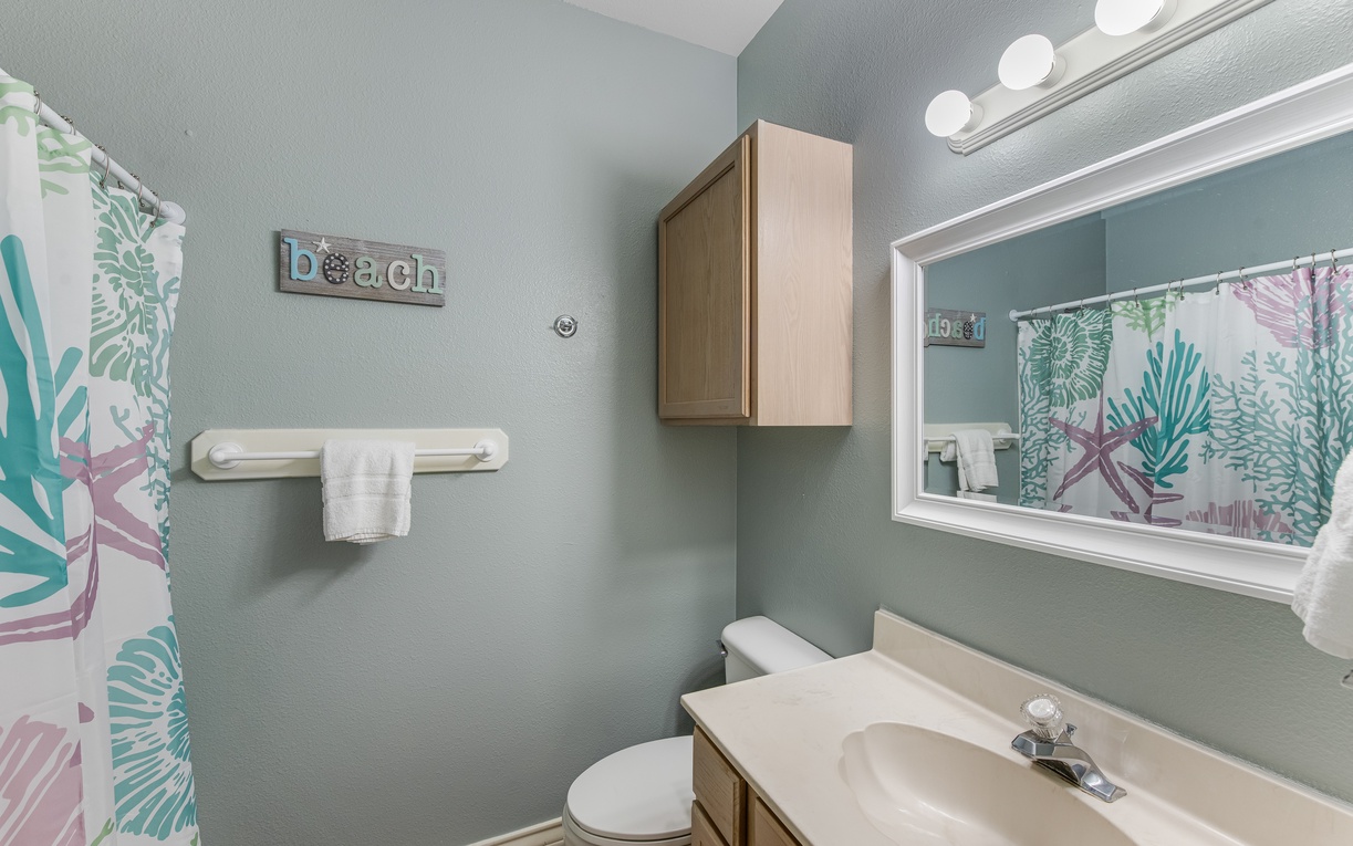 Step into your coastal-inspired bathroom with soothing seafoam walls and tropical touches that make daily routines feel like a beach retreat.