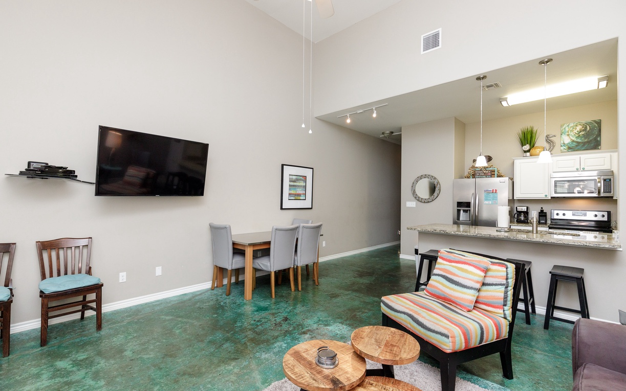 Your spacious open-plan living area flows beautifully from cozy seating to dining table, with a modern kitchen perfect for preparing meals together.