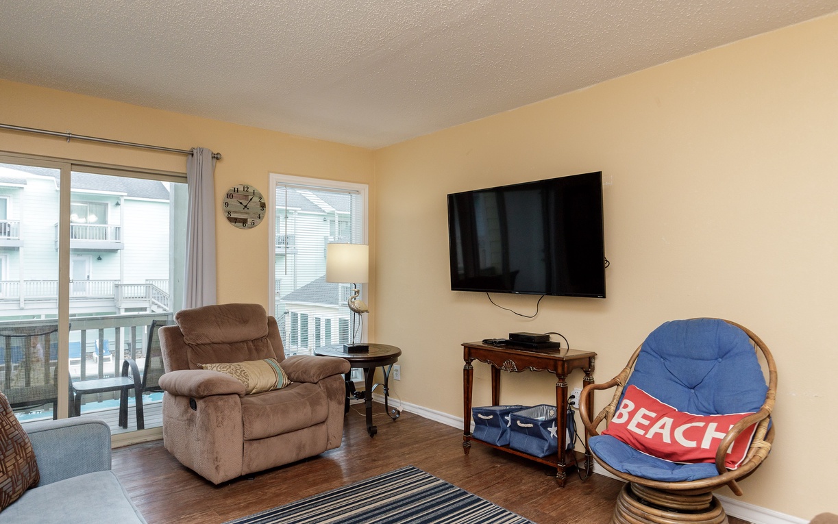 Unwind in your cozy living room with plush seating and entertainment center, perfect for relaxing after beach adventures.