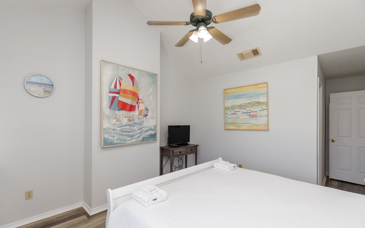 Primary bedroom on the second floor with a king size bed, private balcony, and ensuite bathroom