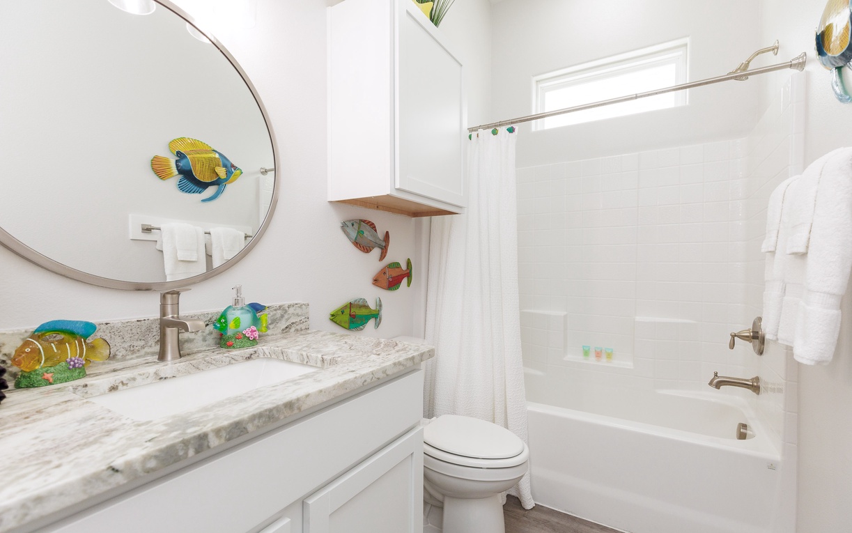 Dive into your whimsical underwater paradise! This charming bathroom features colorful tropical fish artwork that transforms your daily routine into an ocean adventure.