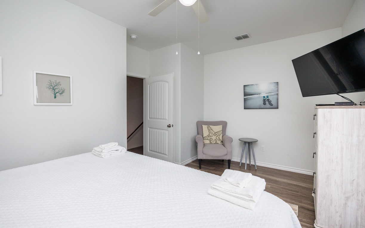 Unwind in your peaceful bedroom with crisp linens, cozy seating nook, and modern amenities for the perfect night's rest.