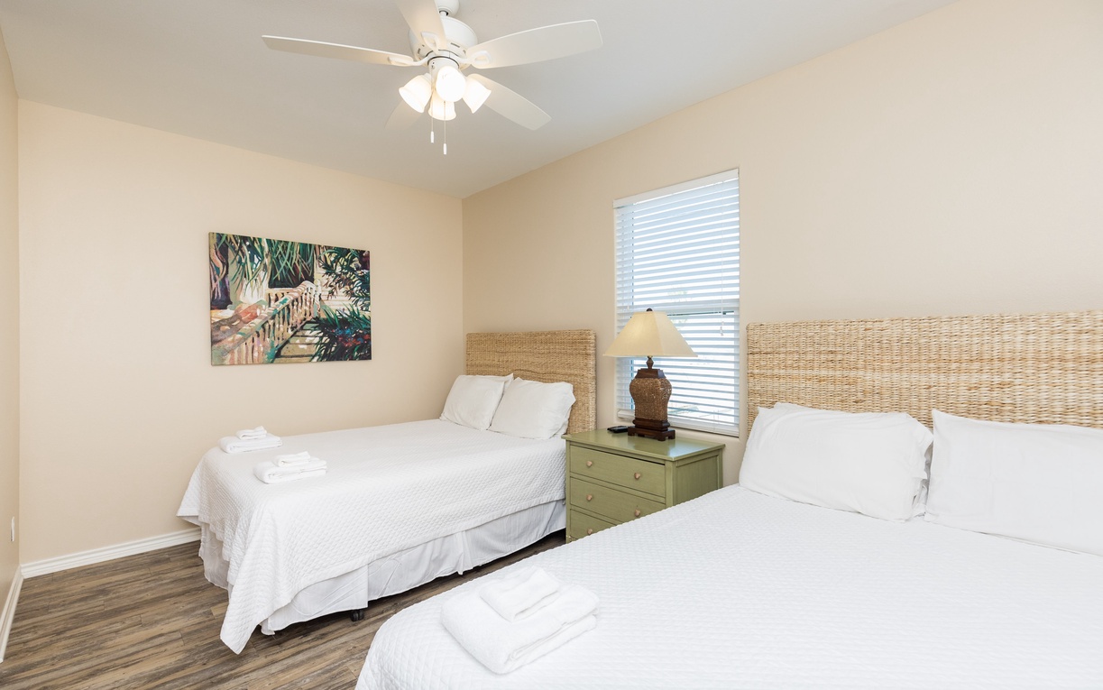 Rest peacefully in your coastal-themed twin bedroom with crisp linens, wicker headboards, and a gentle ceiling fan for ultimate comfort.