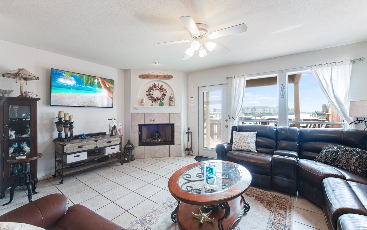 Unwind in your spacious living room with plush leather seating and ocean-themed decor creating the perfect coastal retreat.