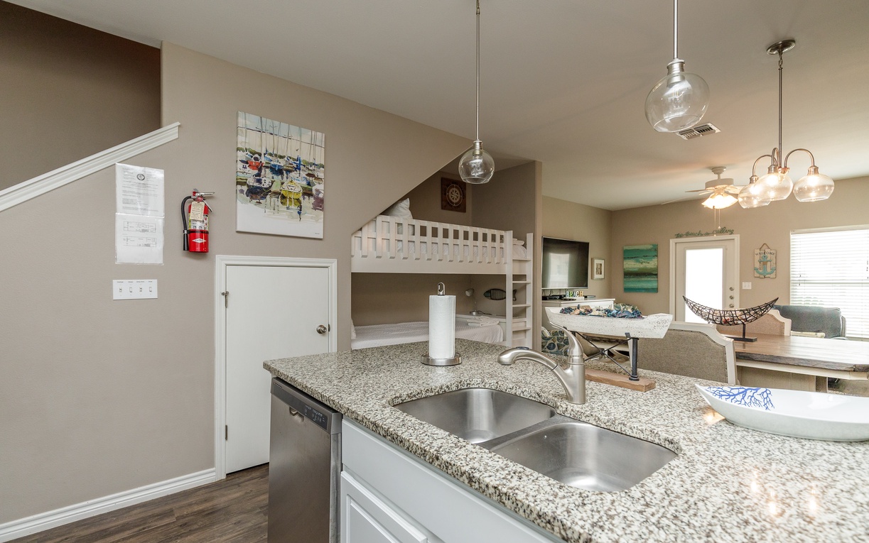 Your open kitchen with granite counters flows seamlessly into the living space, where bunk beds and pendant lighting create a cozy family retreat.