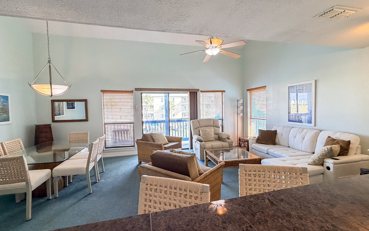 Relax in your spacious living room featuring plush seating and peaceful views through large windows.