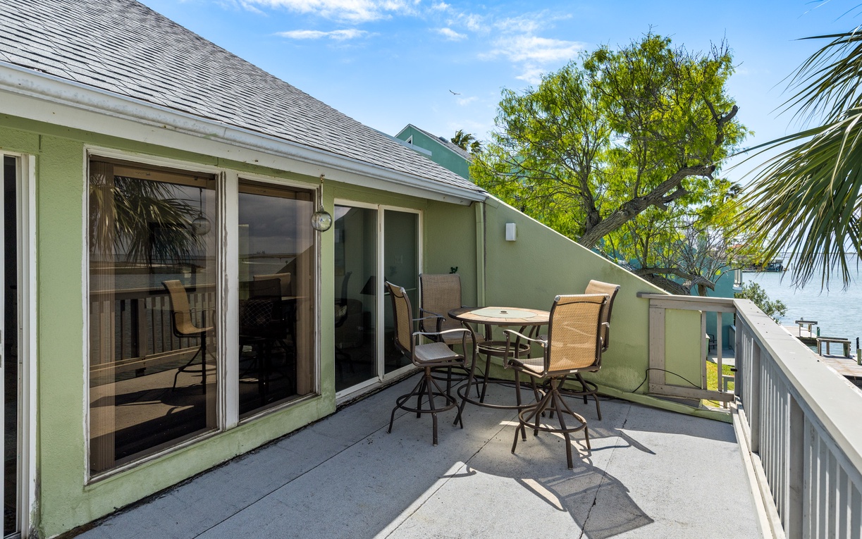 Enjoy morning coffee or sunset cocktails on your private balcony, complete with outdoor dining and partial water views through tropical palms.