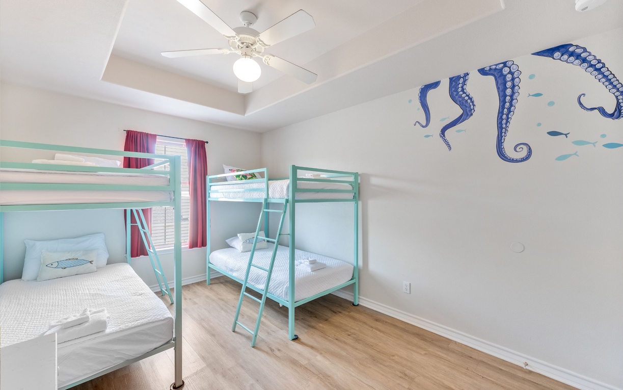 Your kids will love this ocean-themed bunk room with playful octopus murals and cozy sleeping spaces for memorable family adventures.