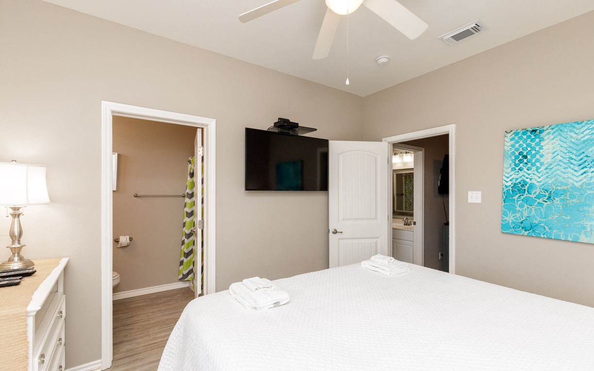 Your peaceful bedroom features crisp white linens, a ceiling fan for cool comfort, and a flat-screen TV for relaxing evenings.