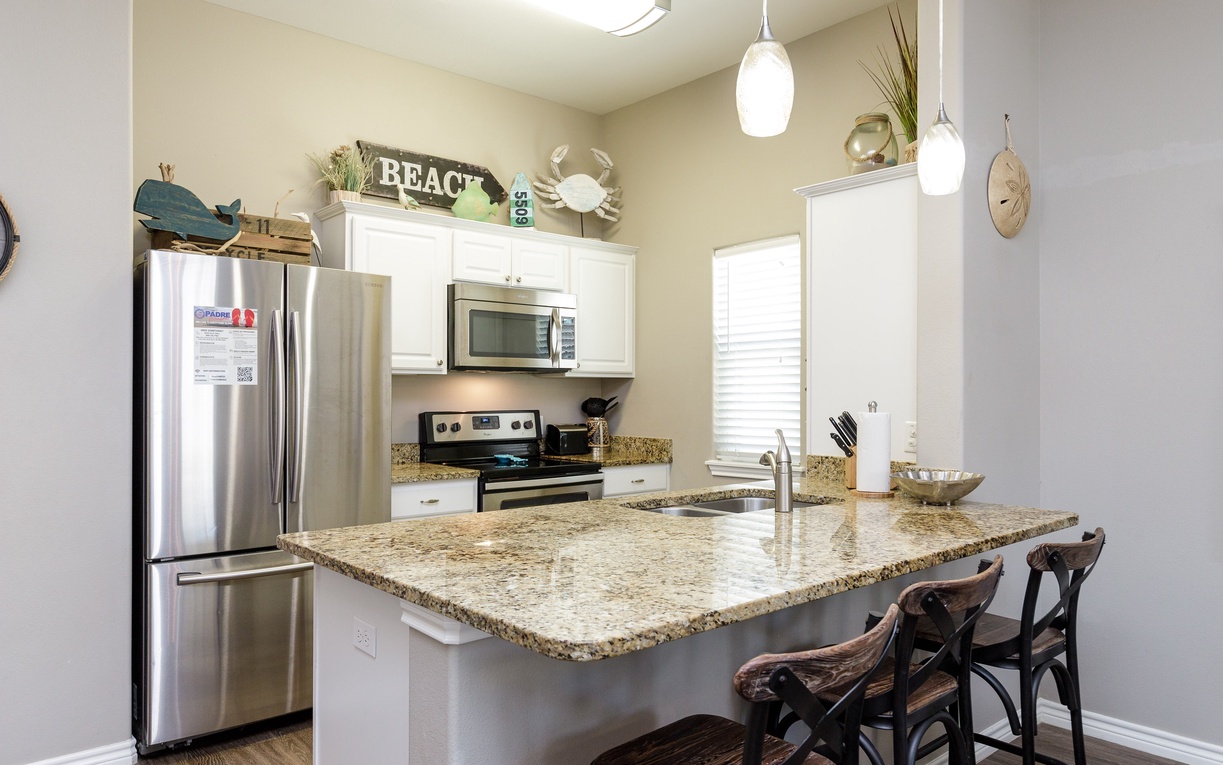 Your fully equipped kitchen features granite countertops, stainless appliances, and charming beach-themed touches that make cooking a delightful coastal experience.