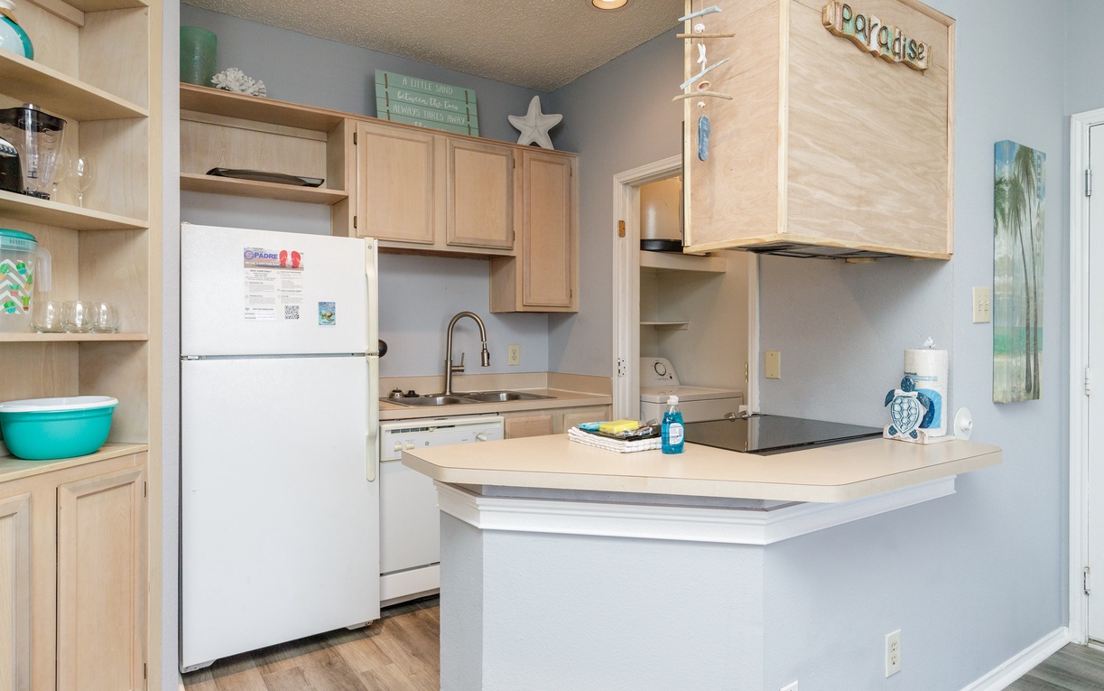 Cook your favorite meals in this bright, fully equipped kitchen with modern appliances and beach-themed touches.