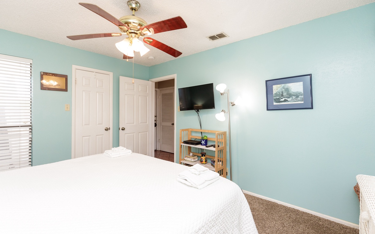 Relax in your peaceful bedroom with a king size bed, ceiling fan, and entertainment center for ultimate comfort.