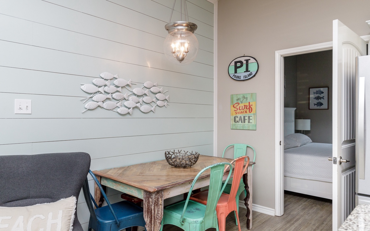 Step into your coastal dining nook where shiplap walls and beach-themed art create the perfect backdrop for morning coffee.