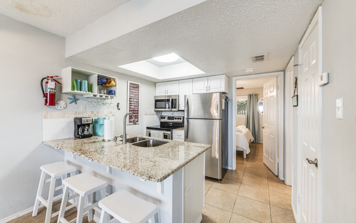 Your bright, fully-equipped kitchen features granite counters, stainless appliances, and a breakfast bar perfect for morning coffee.