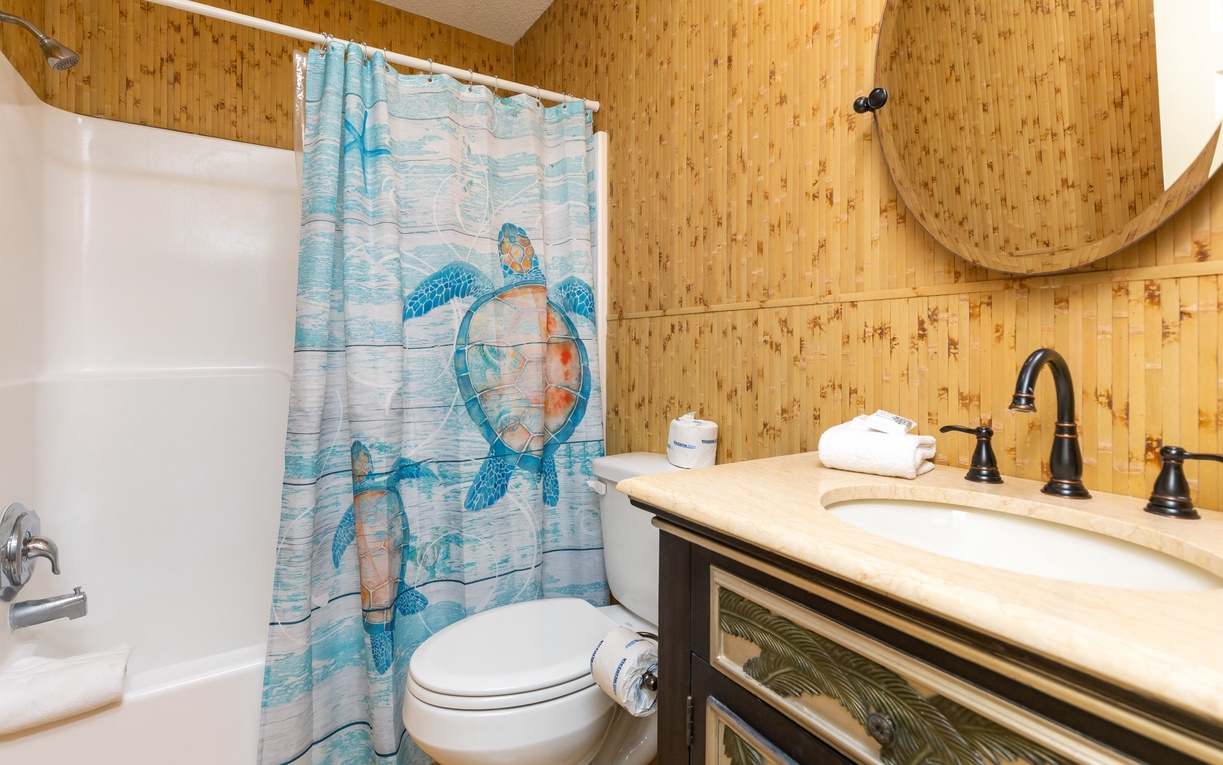 Step into your coastal-themed bathroom featuring a charming sea turtle shower curtain and warm bamboo accents that create a tropical paradise retreat.