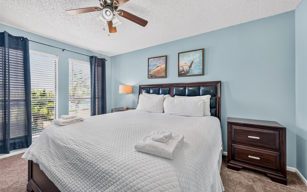 Drift off in this serene bedroom with plush linens, coastal charm, and soft breezes from your ceiling fan keeping you comfortable all night.
