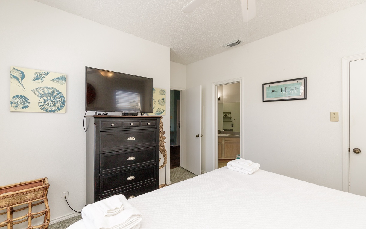 Relax in your peaceful bedroom featuring coastal artwork, convenient storage, and your own private bathroom just steps away.
