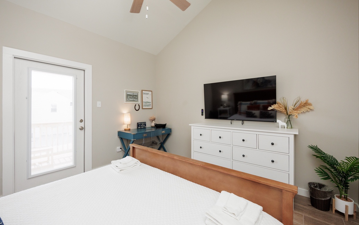 Unwind in your serene bedroom featuring a smart TV, cozy work desk, and thoughtful touches like fresh linens and natural decor for complete relaxation.