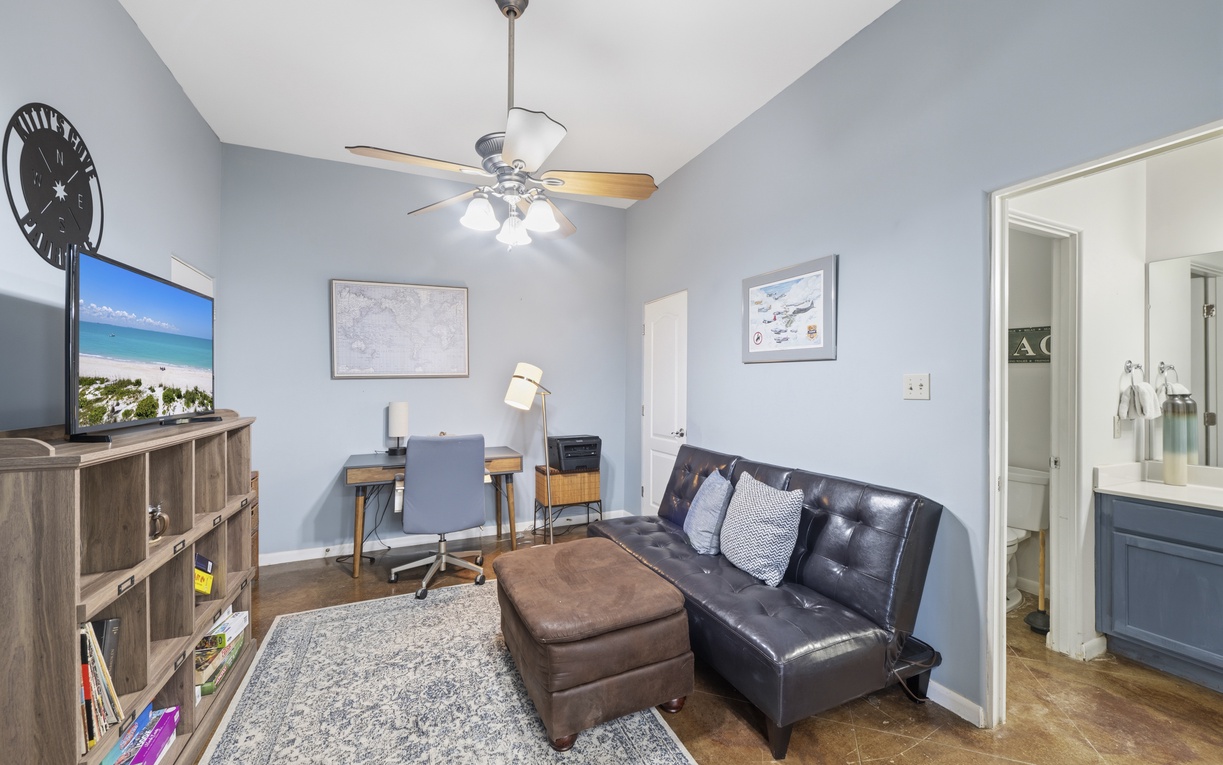 Unwind in your cozy living space featuring a plush sectional sofa perfect for movie nights, complemented by a dedicated workspace and calming coastal hues that invite you to truly relax.
