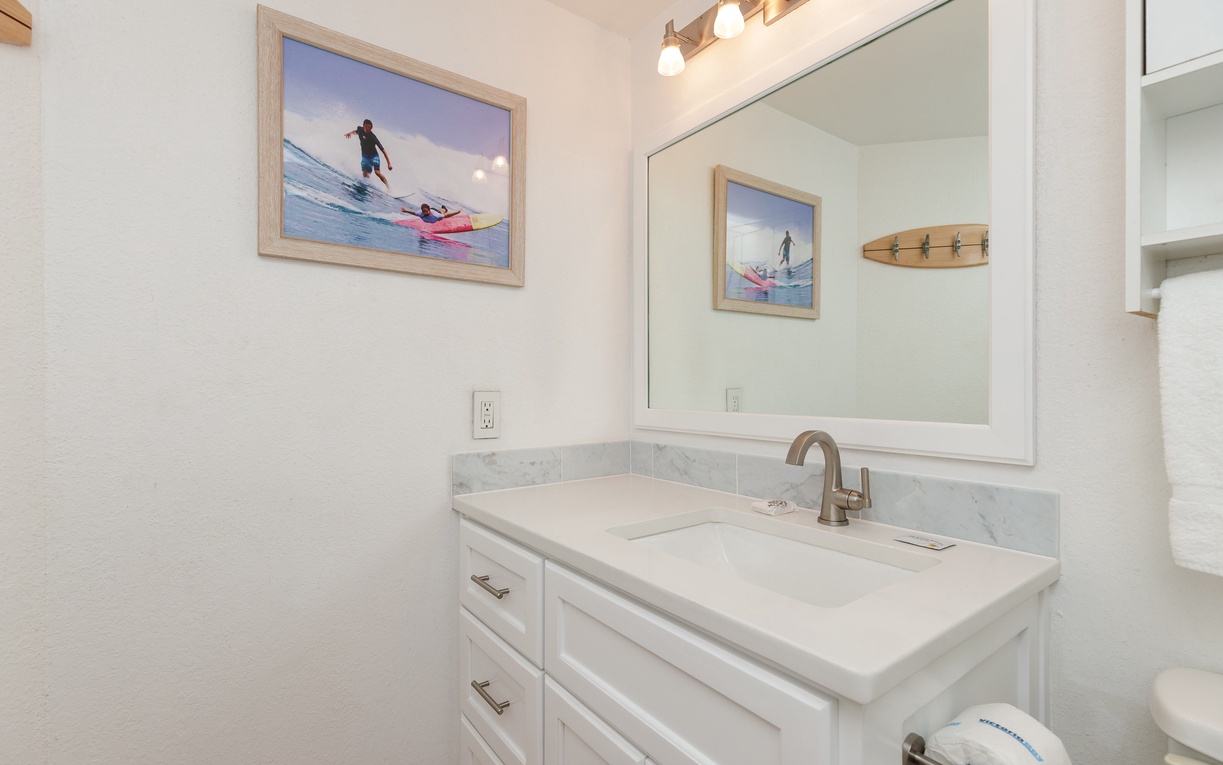 Your bright bathroom features marble countertops, coastal artwork, and premium fixtures for your daily refresh rituals.