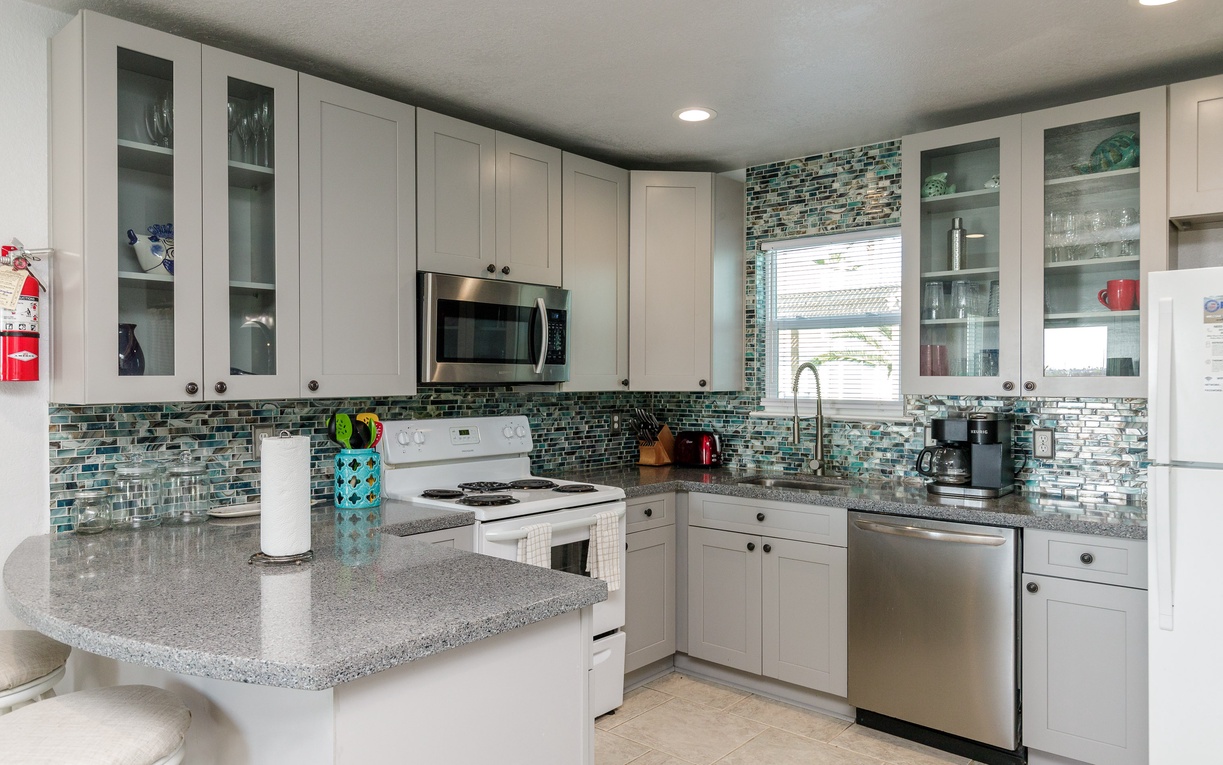 Your fully-equipped kitchen features granite counters, glass tile backsplash, and everything you need to prepare delicious meals together.