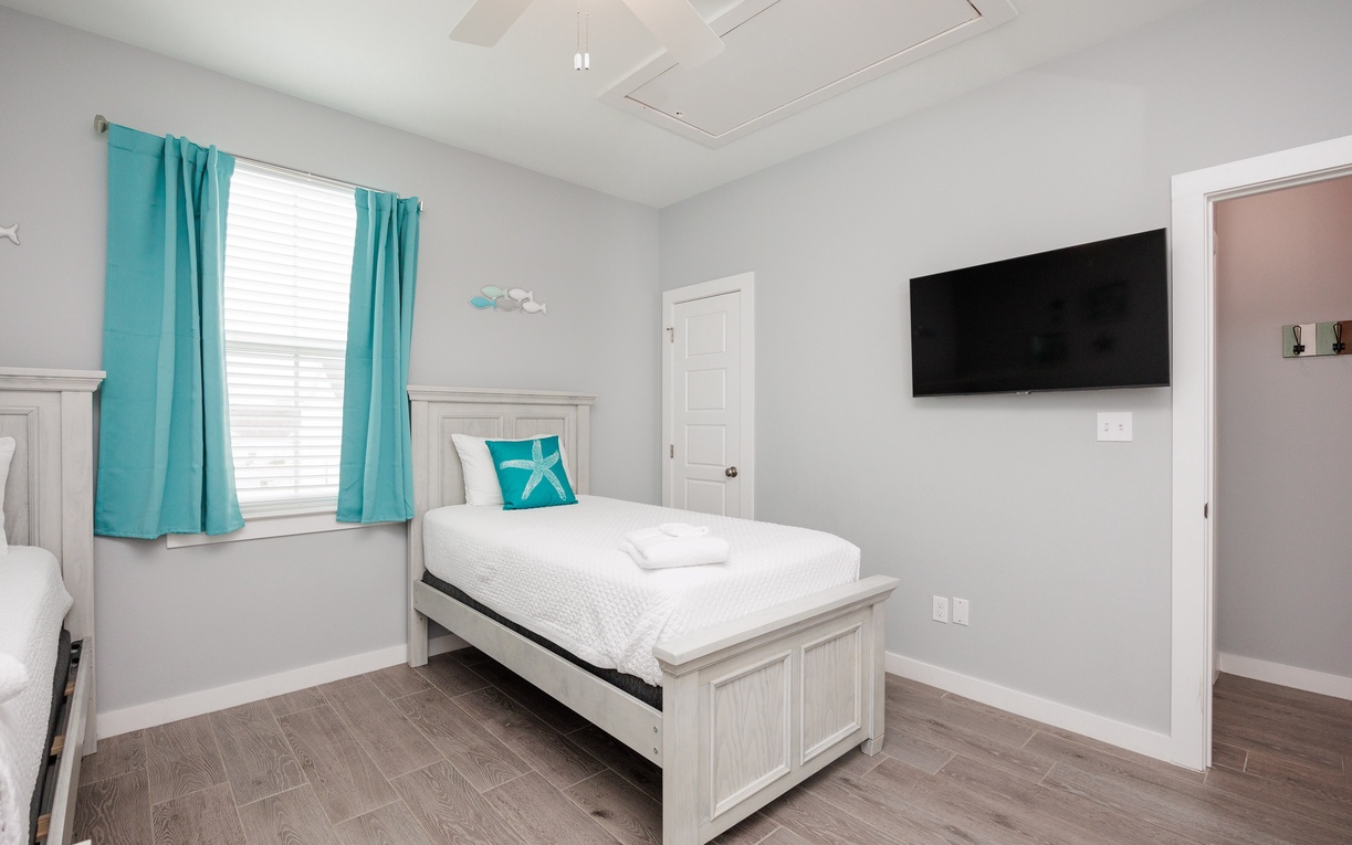 Rest peacefully in your bright bedroom with fresh linens, turquoise accents, and entertainment ready for cozy nights in.