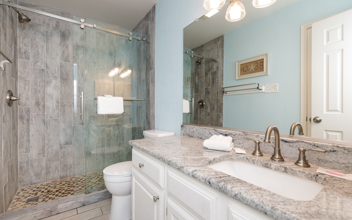 Unwind in your spa-like bathroom with granite counters, glass shower, and calming blue walls.