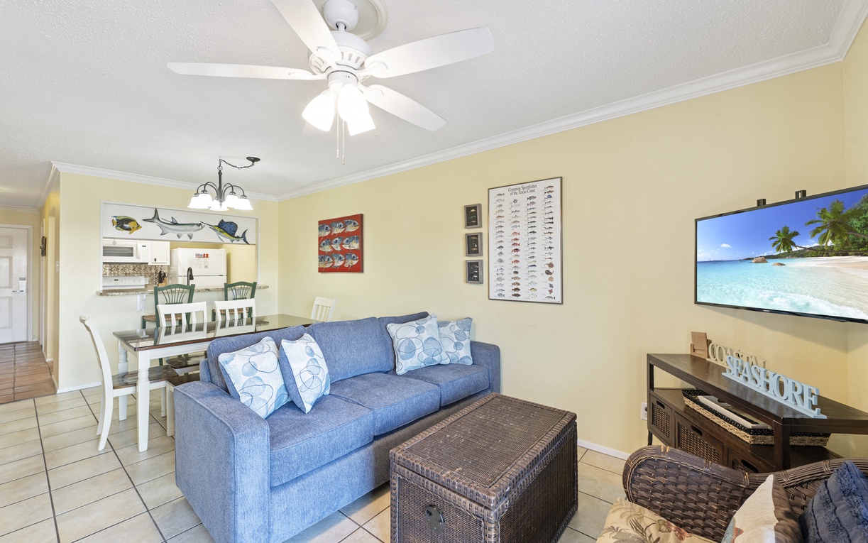 Unwind in your bright, coastal-themed living space with comfortable seating and entertainment center perfect for relaxing evenings.