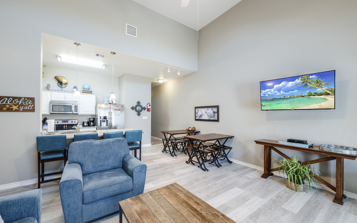 Unwind in your spacious open-plan living area where coastal décor meets modern comfort, complete with kitchen bar seating and entertainment center.