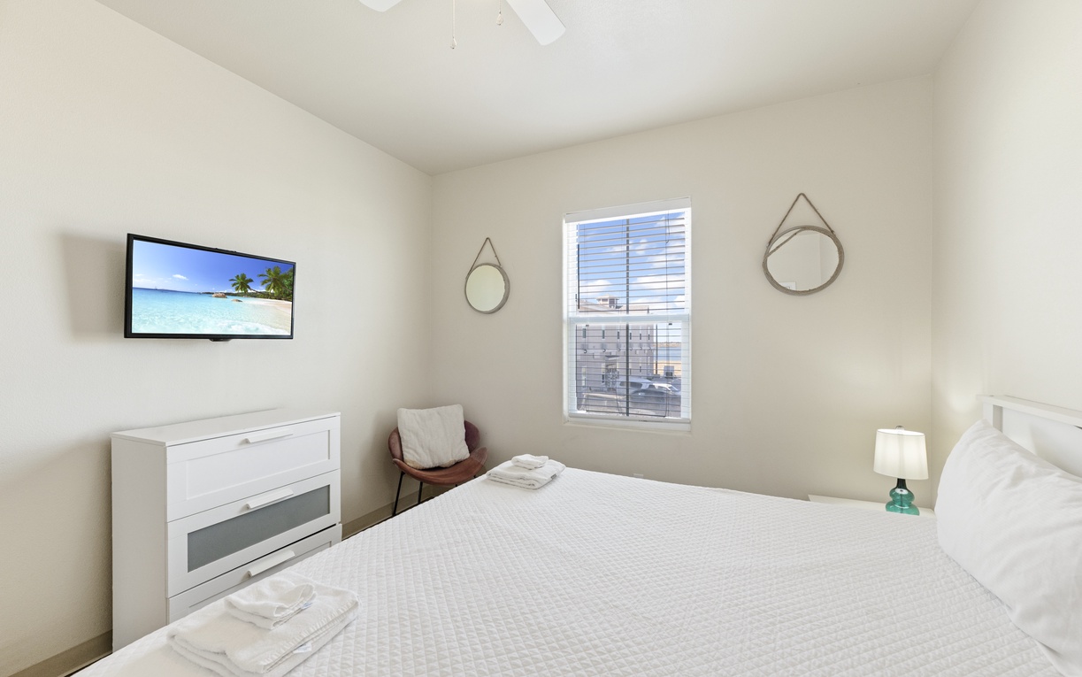 Unwind in your bright, peaceful bedroom with crisp linens, wall-mounted TV, and city views.