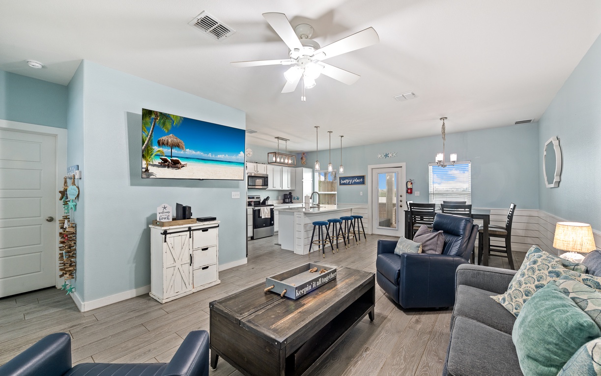 Soothing blue walls and modern beach-house charm create the perfect coastal retreat. This open-plan space flows effortlessly from living to dining to kitchen, ideal for gathering and unwinding.