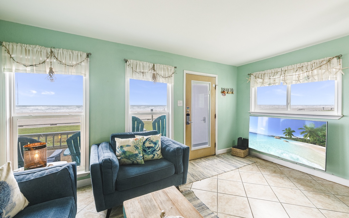 Sink into comfortable seating while enjoying panoramic ocean views through multiple windows. Your beach getaway feels instantly relaxing with coastal décor and tropical touches throughout.