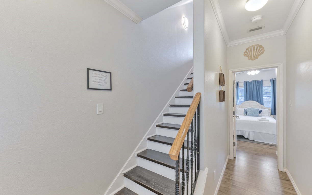 Move effortlessly between floors in this bright, welcoming hallway. Your coastal-inspired bedroom awaits at the top of these elegant stairs.