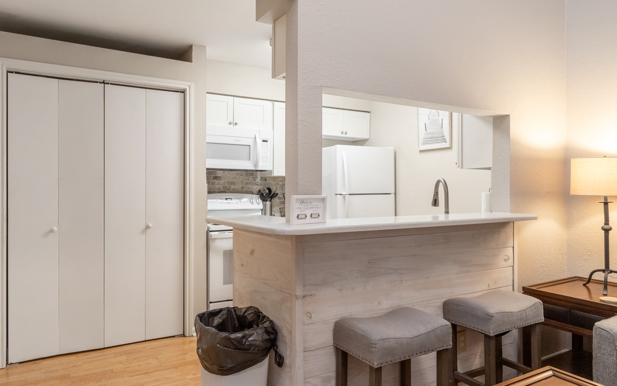 Your fully equipped kitchen features modern appliances and a breakfast bar where you can enjoy morning coffee and plan adventures.
