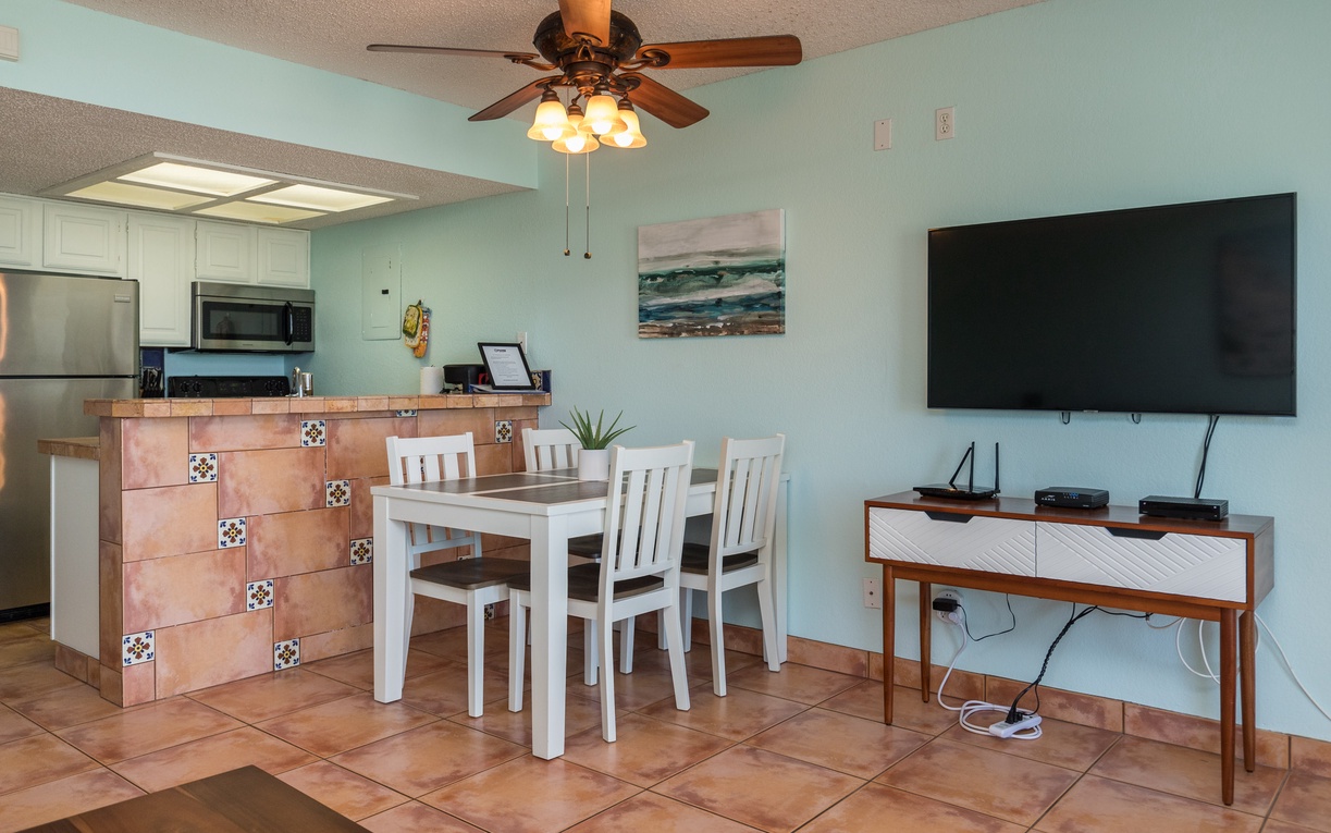 Your open-concept living space combines kitchen, dining, and entertainment in coastal style with modern amenities and soothing sea-themed decor.