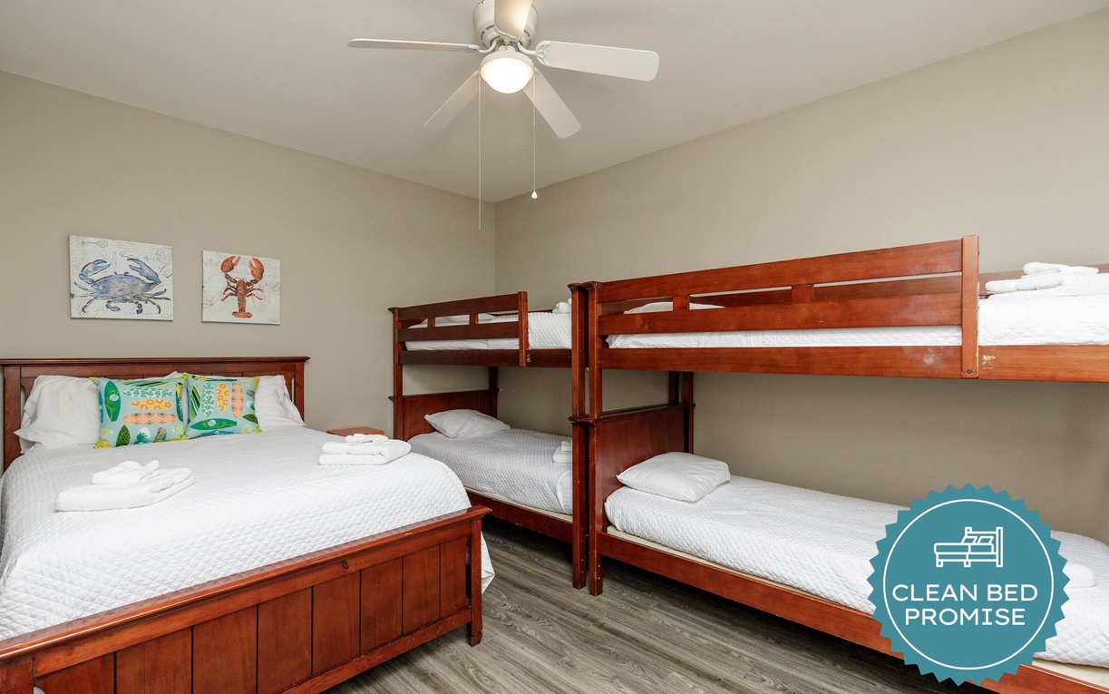 Your spacious bedroom features crisp linens and coastal art, perfect for families with both queen and bunk beds.