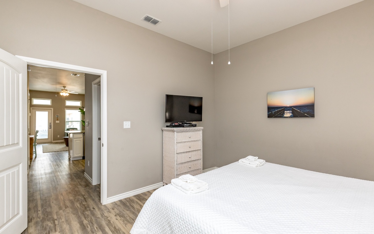 Relax in your serene bedroom with soft lighting, plush white bedding, and your own flat-screen TV for peaceful evenings.