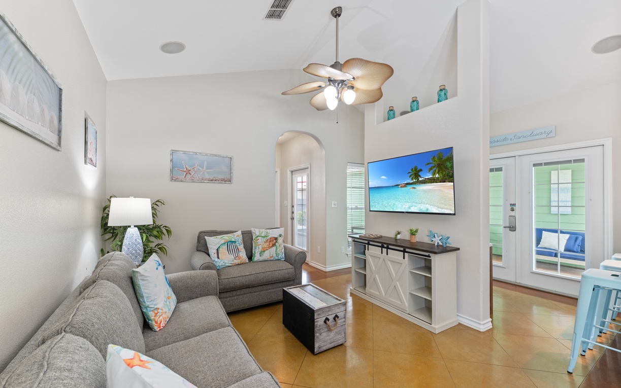 Sink into plush seating while tropical breezes flow through your bright living space, complete with coastal charm and modern entertainment.