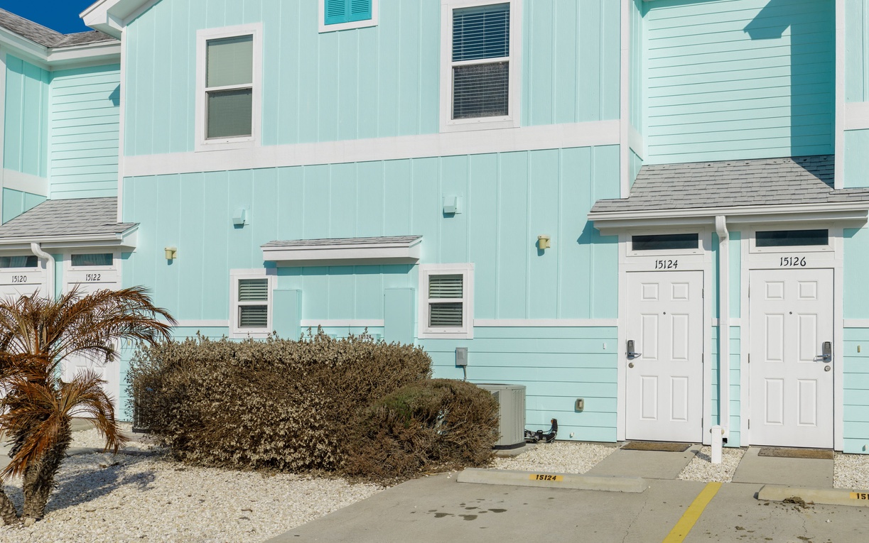 Charming turquoise townhomes with white trim create a cheerful coastal atmosphere for your beach getaway.
