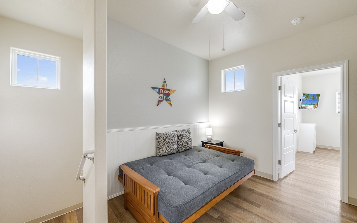 Your cozy bedroom features a comfortable bed, ceiling fan for perfect temperature, and cheerful Texas-themed decor to make you feel at home.