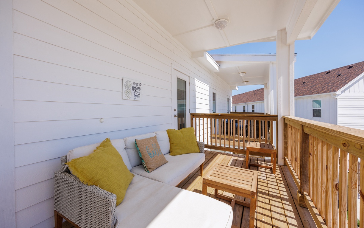 Settle into your private covered balcony where comfortable seating and warm wood tones create the perfect spot to unwind with morning coffee or evening relaxation.