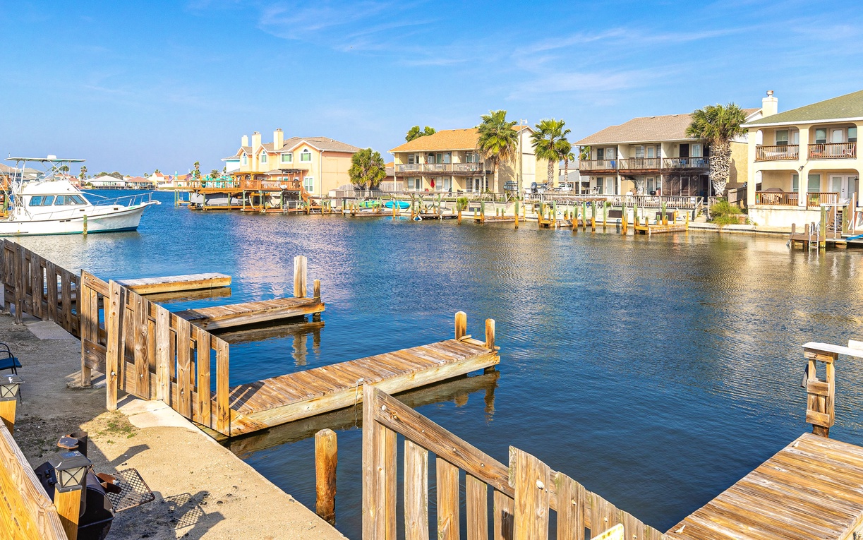 Waterfront community with private docks and boat slips surrounded by coastal homes and palm trees.
