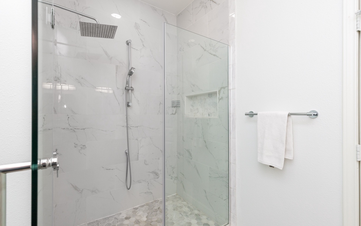 Step into your luxurious marble shower with rainfall and handheld options. Crisp white towels await you after your rejuvenating retreat.