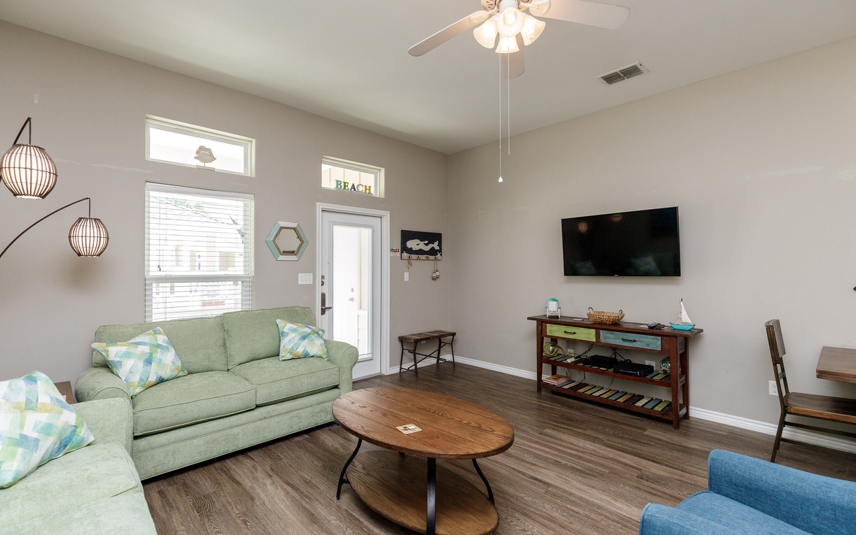 Unwind in your bright coastal retreat with comfy seating, sleeper sofa, modern TV, and charming beach decor that makes relaxing effortless.