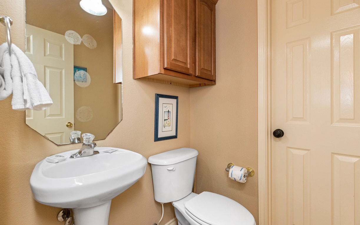 Your private powder room features warm wood cabinetry and thoughtful touches, creating a welcoming space for freshening up.