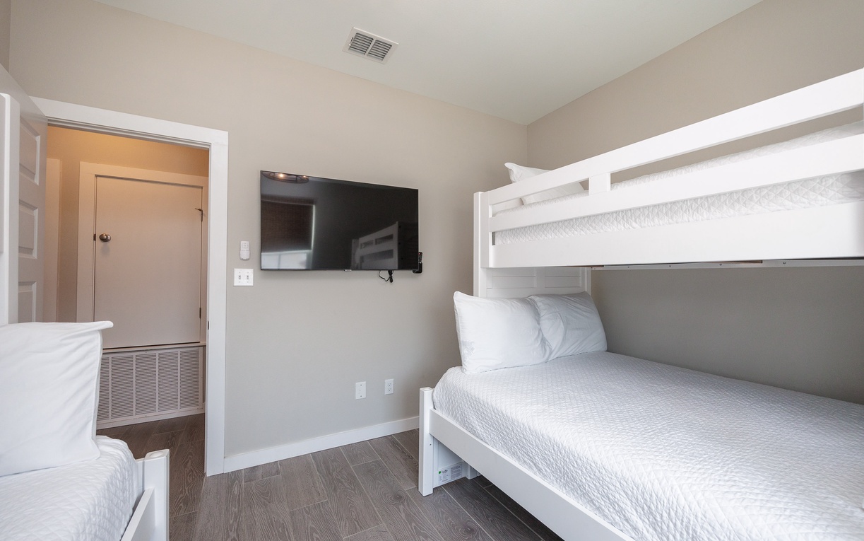 Your family's cozy bunk room features crisp white linens and modern amenities, perfect for kids' adventures and restful nights together.