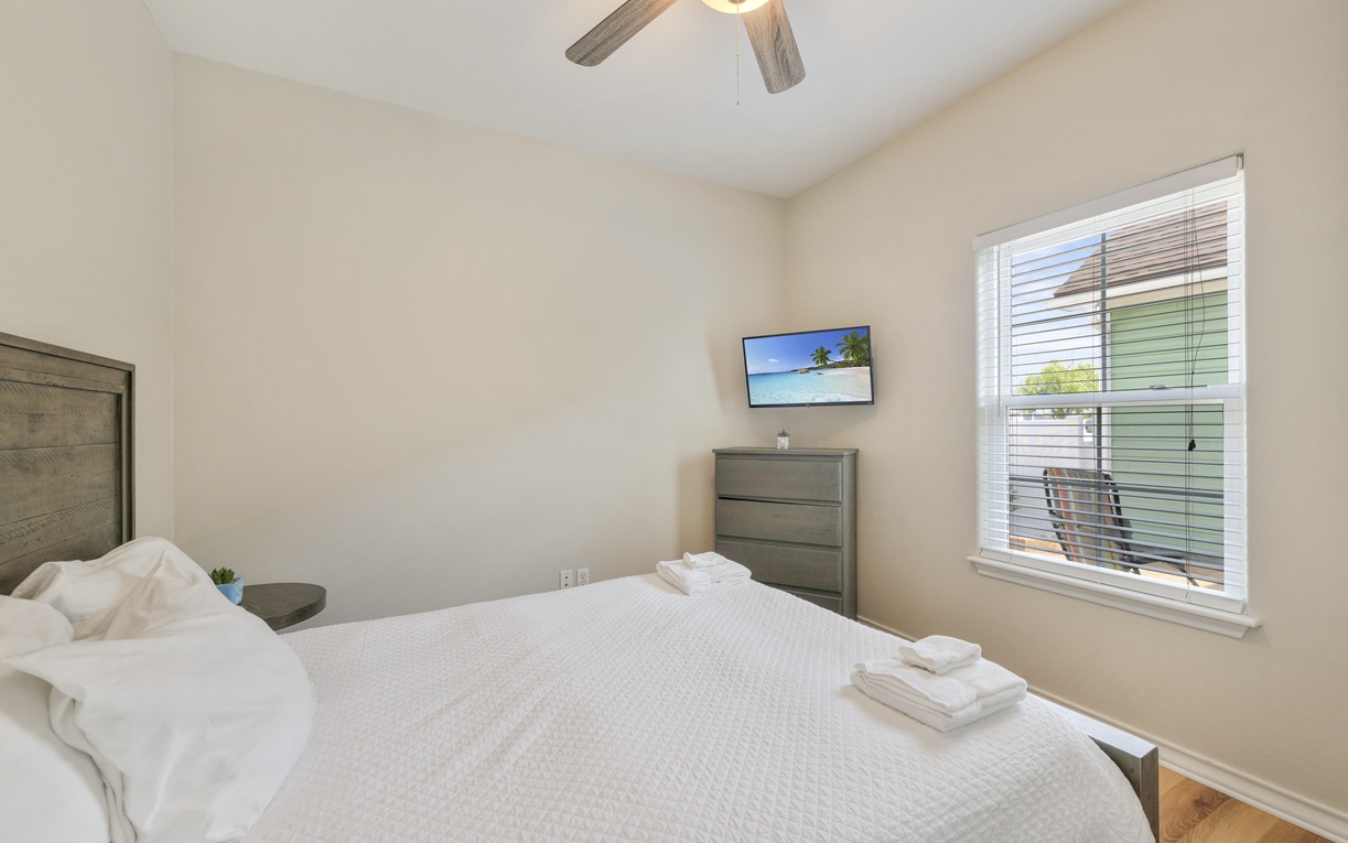 Slip into fresh linens and let the ceiling fan's gentle breeze lull you to sleep in this serene bedroom retreat. Your comfort awaits with plush towels, ample storage, and a quiet space to unwind.
