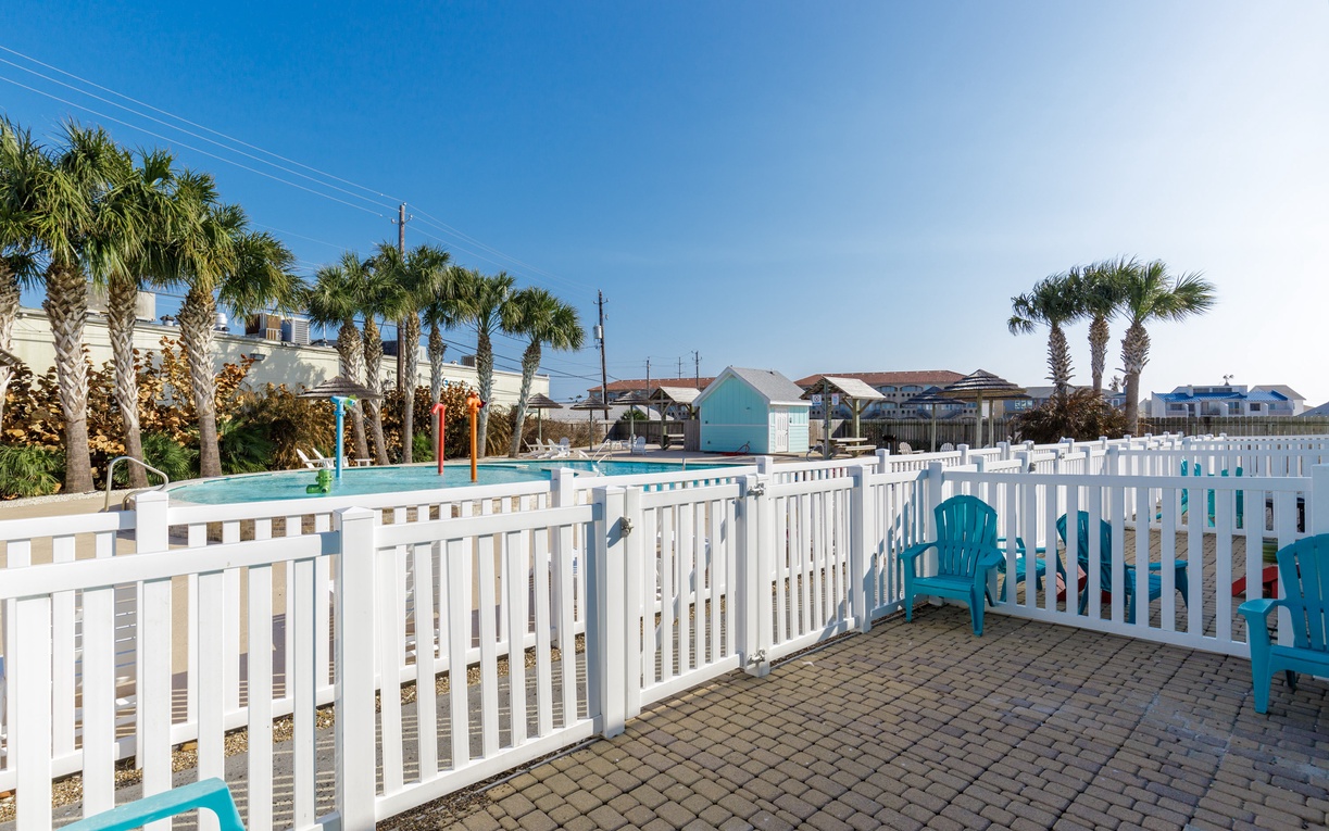 Your private fenced terrace offers poolside seating and palm-studded views in this tropical coastal setting.