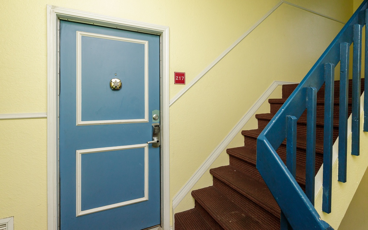 Your cheerful entrance awaits on the second floor, where bright blue accents and warm yellow walls create a welcoming atmosphere.