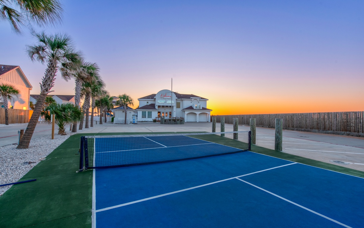 Challenge friends to Pickleball matches on the community court as golden sunsets paint the tropical sky behind swaying palms.